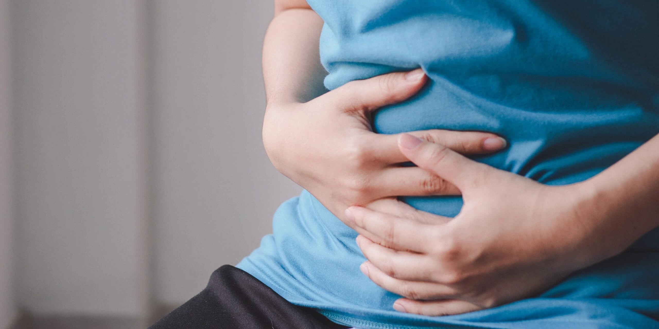 Frau hält sich den Bauch