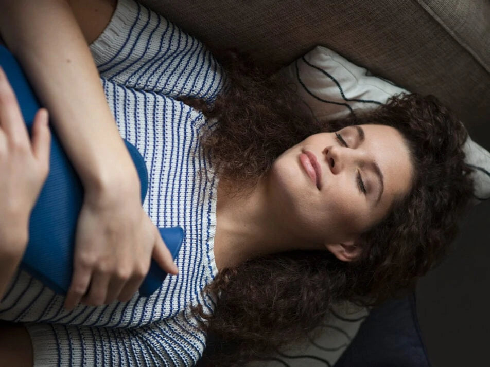 Frau mit Wärmflasche im bett