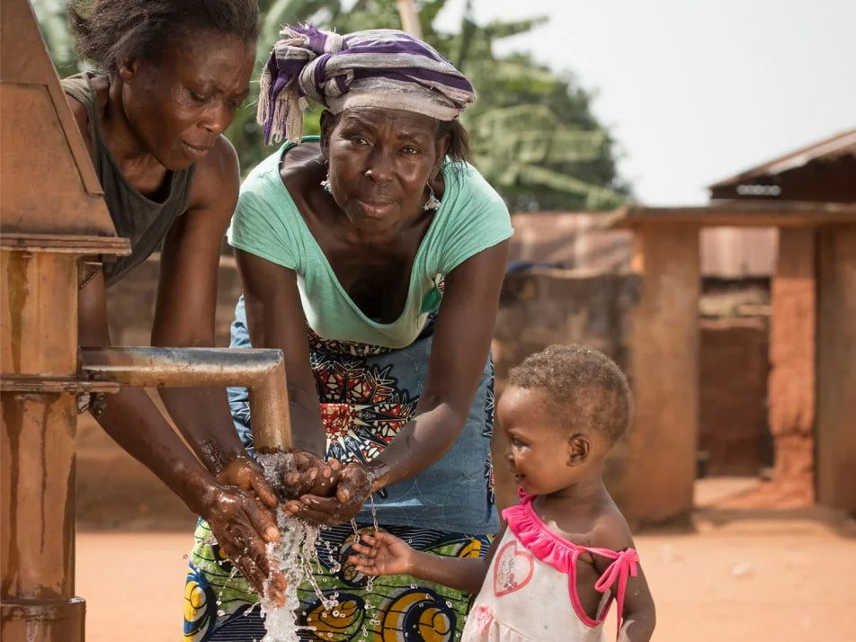 Drei Frauen an einem Brunnen