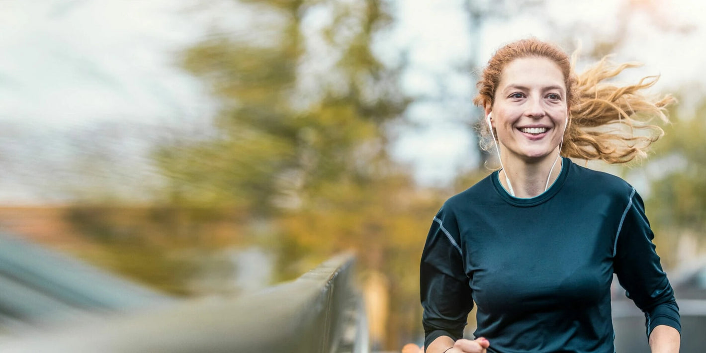 Frau mit Kopfhörern im Ohr am Joggen