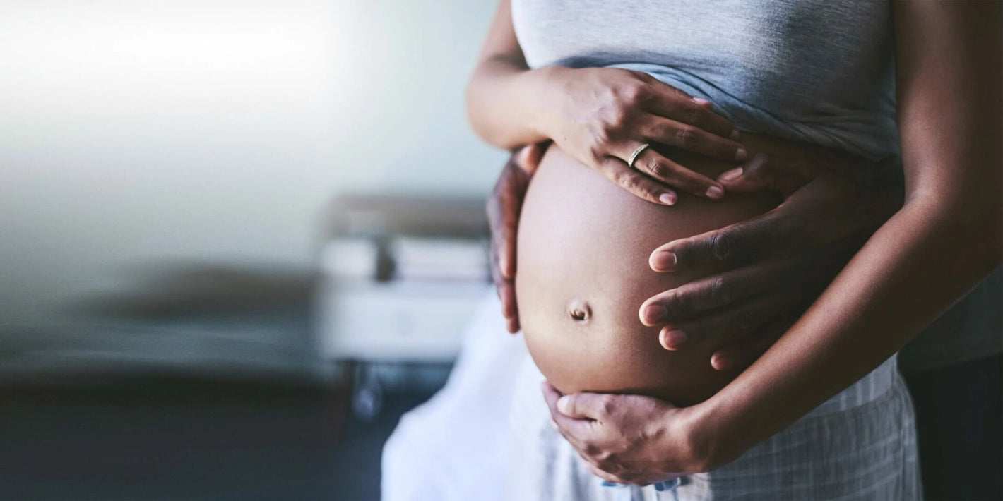 Ein Partner hält den Bauch seiner schwangeren Frau